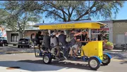 A group of people enjoys a ride on a pedal-powered