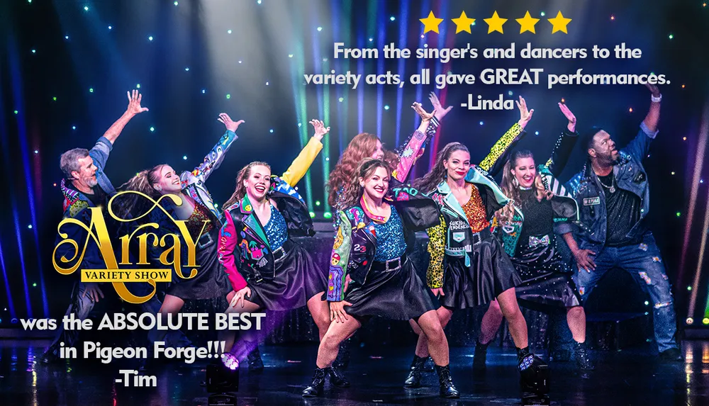 A group of lively performers are dancing on stage in colorful outfits with vibrant lighting effects in the background