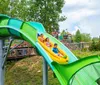 A group of people enjoy a ride on a yellow raft sliding down a water slide with an inset of a person having fun on a separate slide